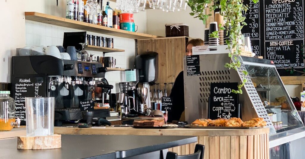 Contemporary cafe with wooden accents and hanging plants, offering a warm, inviting atmosphere for coffee lovers.